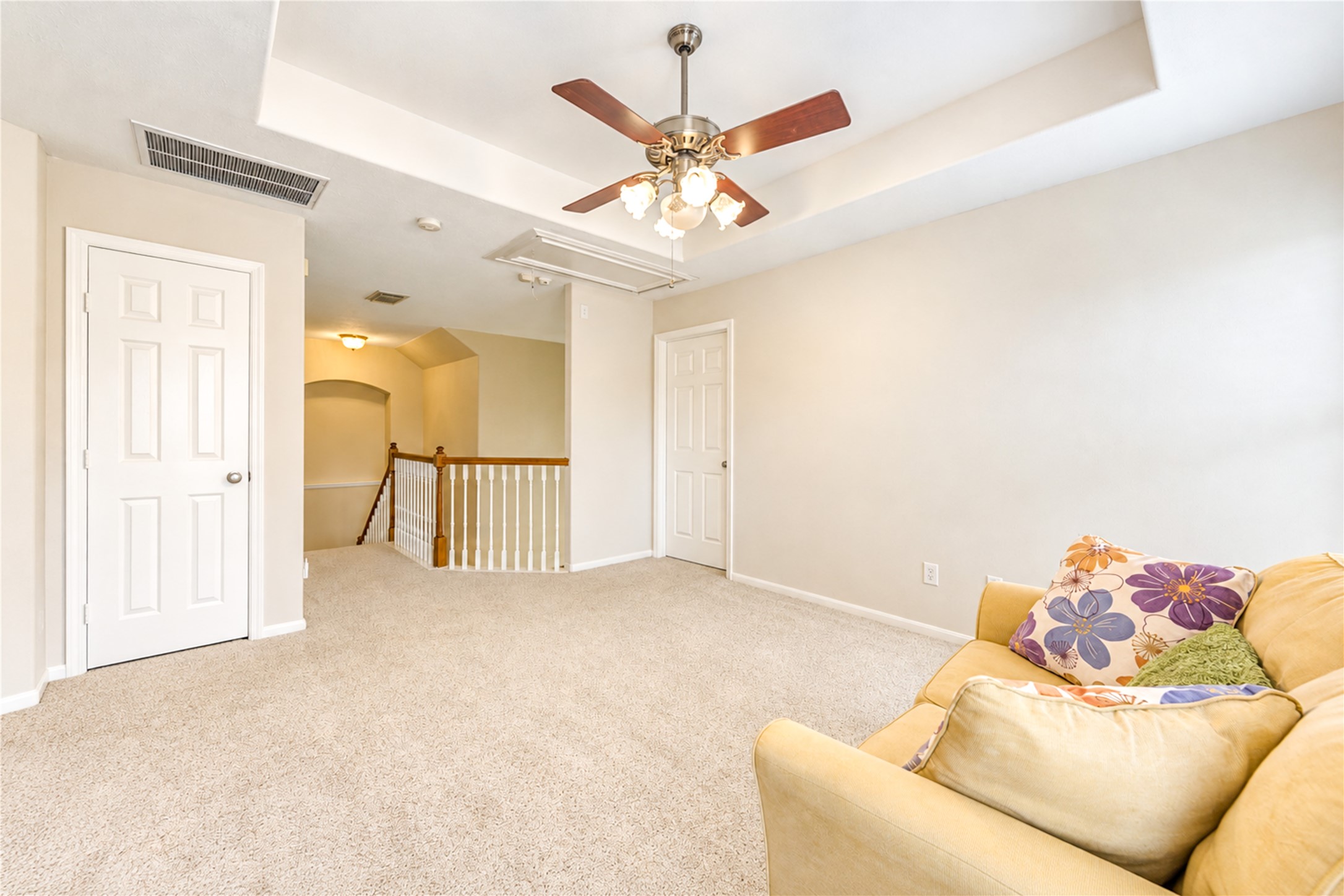 12806 Ridge Bank Lane Houston, TX 77041 - Photo 34 of 44 Bright and inviting loft area with plush carpeting, ceiling fan, and neutral walls, perfect for relaxation or an additional living space.