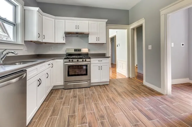 a kitchen with cabinets oven and a wooden floor
