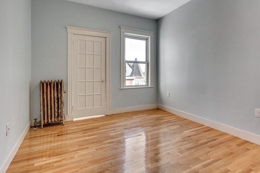 5 Greenheys Street, Unit 2 Boston, MA 02121 - Photo 4 of 10 an empty room with wooden floor and windows