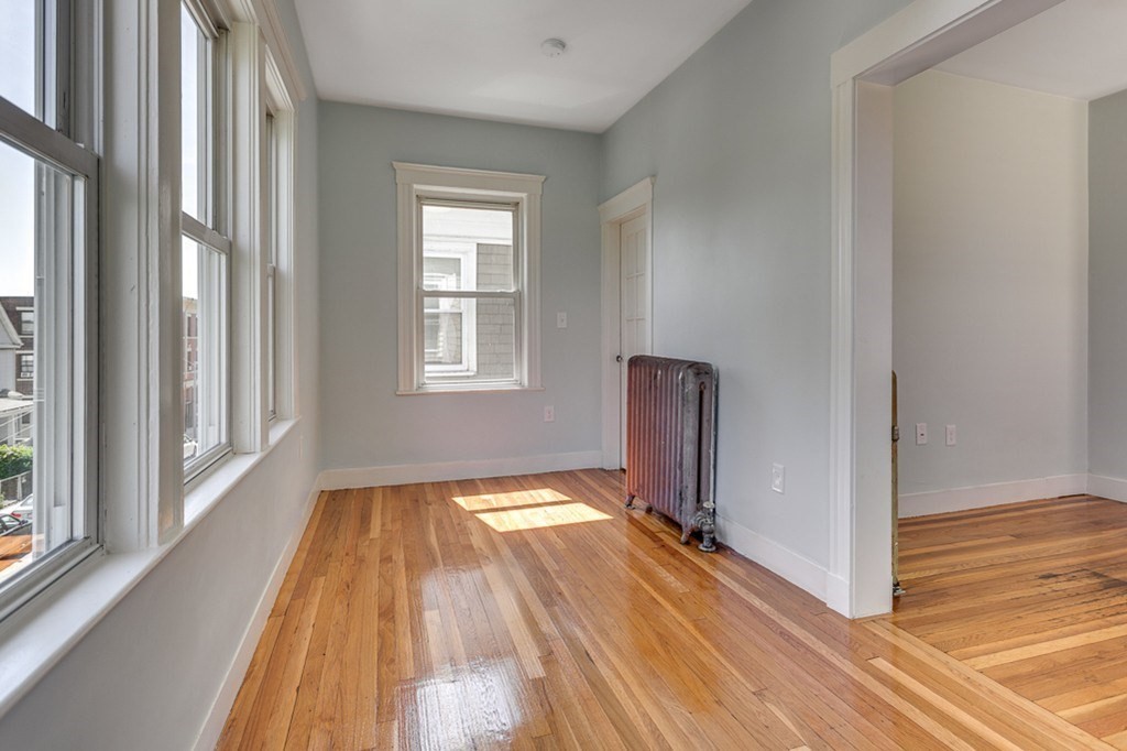 5 Greenheys Street, Unit 2 Boston, MA 02121 - Photo 7 of 10 a view of a room with wooden floor a fireplace and windows