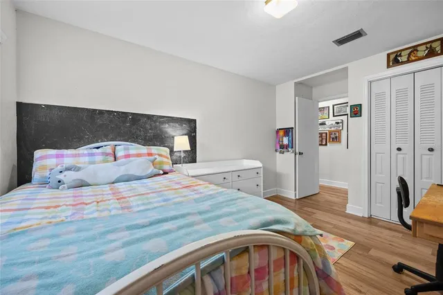 a bedroom with a bed and a large mirror on the dresser