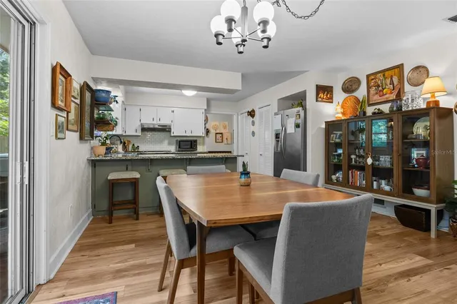 a dining hall with stainless steel appliances granite countertop a dining table and chairs with wooden floor