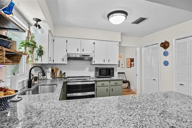 a kitchen with stainless steel appliances a stove a sink and a refrigerator