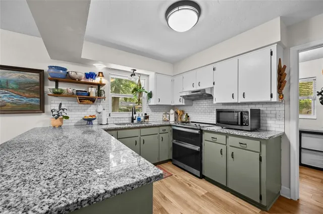 a kitchen with kitchen island granite countertop a sink cabinets and window
