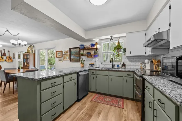 a kitchen with granite countertop cabinets stainless steel appliances a sink and a window
