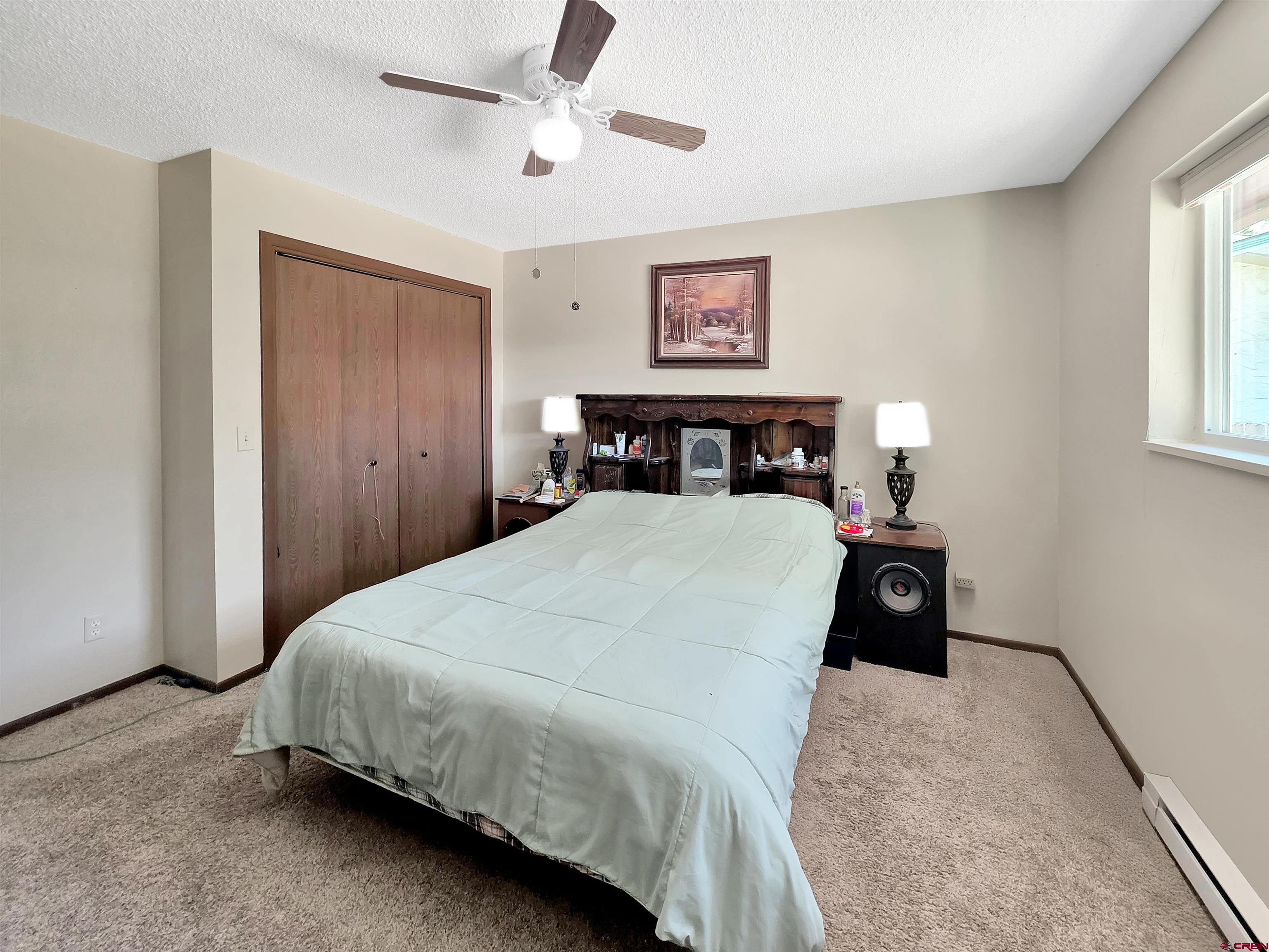 613 Colorado Street Cortez, CO 81321 - Photo 11 of 19 a bed room with a bed and a chandelier