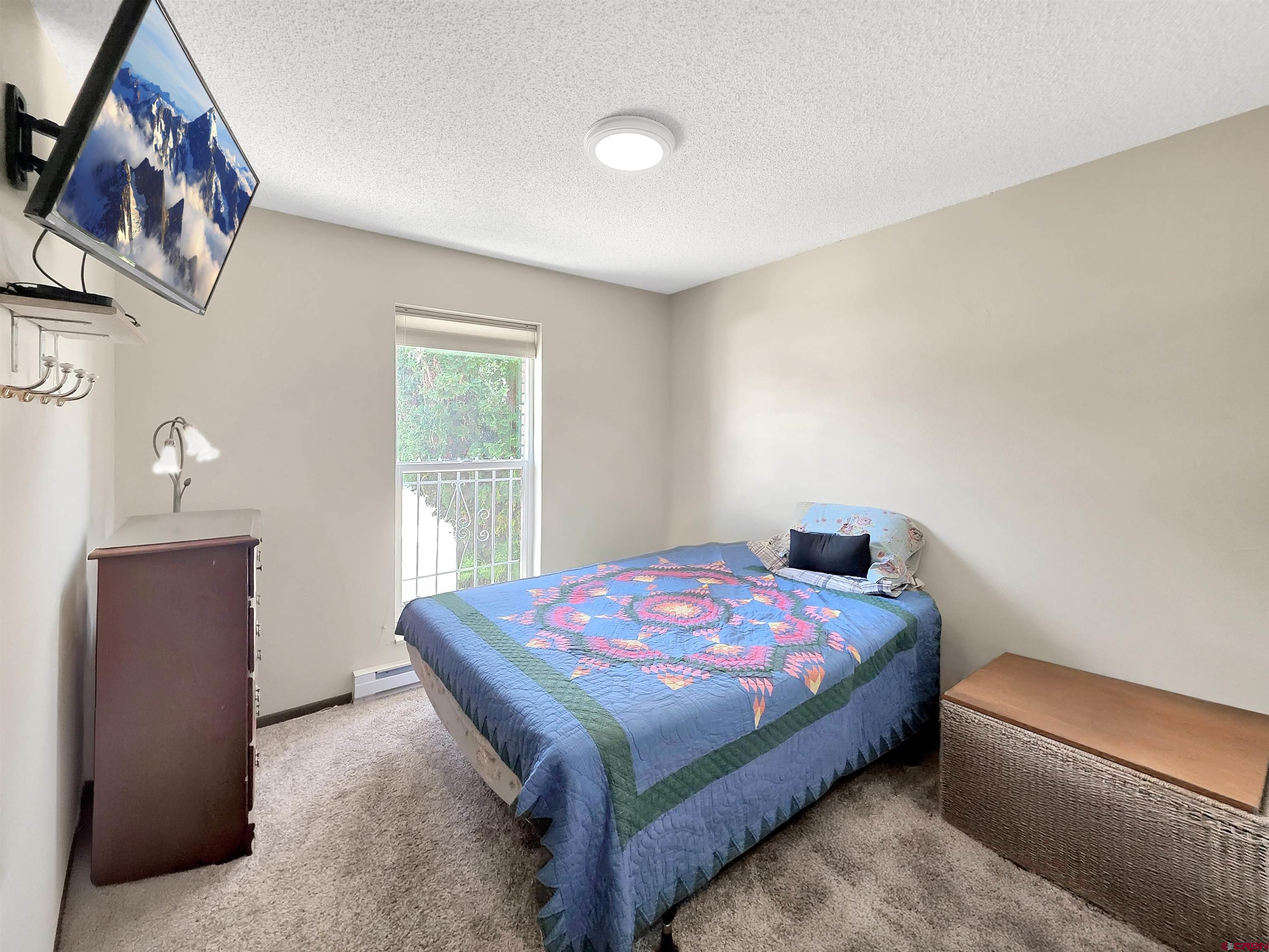 613 Colorado Street Cortez, CO 81321 - Photo 13 of 19 a bedroom with a bed and a window