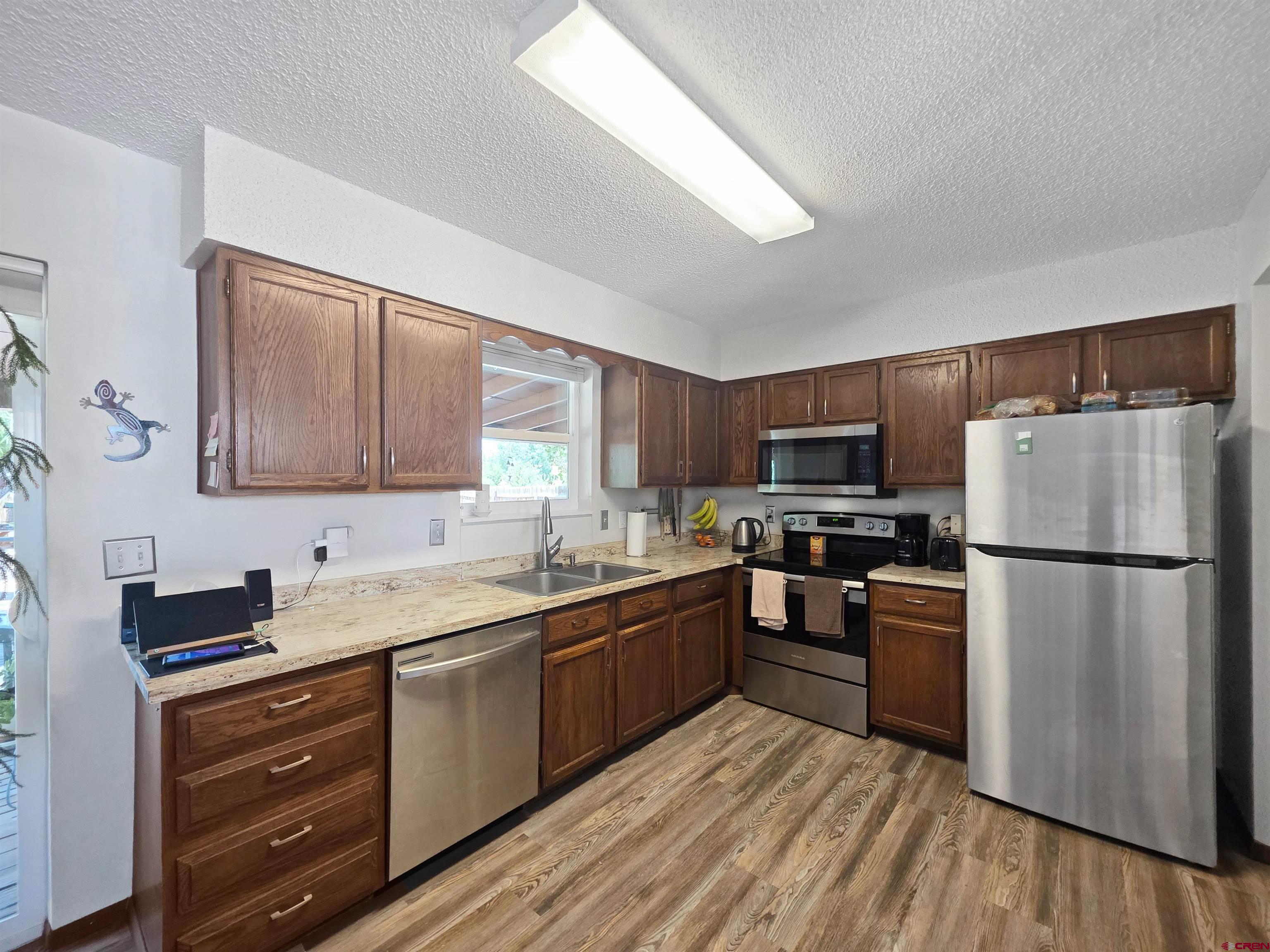 613 Colorado Street Cortez, CO 81321 - Photo 9 of 19 a kitchen with wooden cabinets and stainless steel appliances