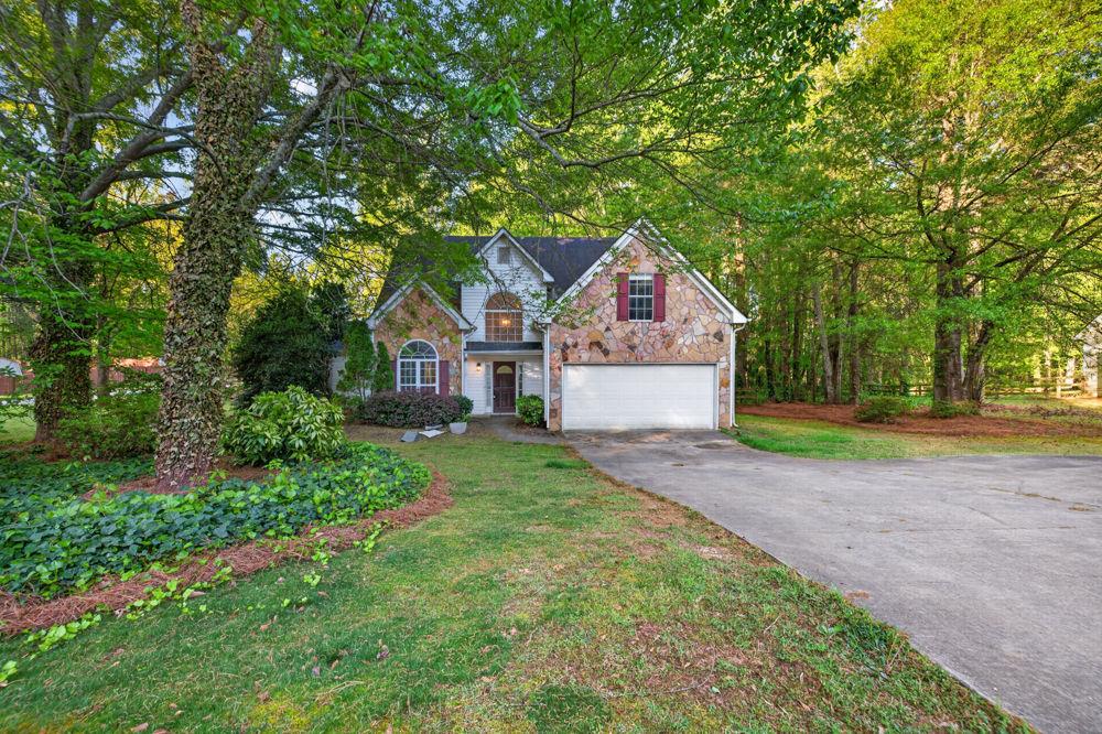 a front view of a house with a yard and trees