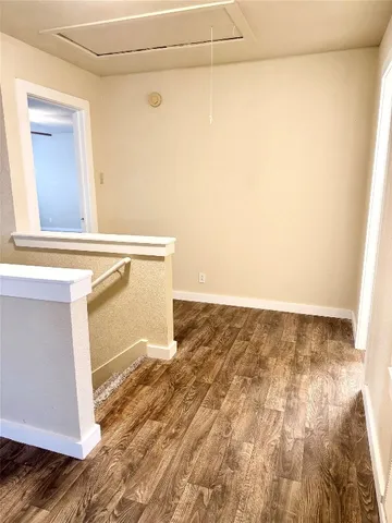 a view of a room with wooden floor and a window