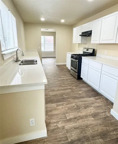 a kitchen with a sink a stove top oven and white kitchen