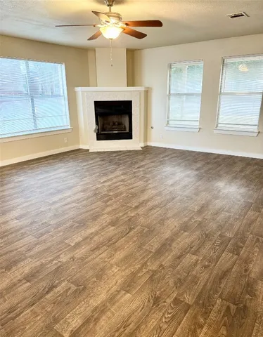 an empty room with windows and fireplace