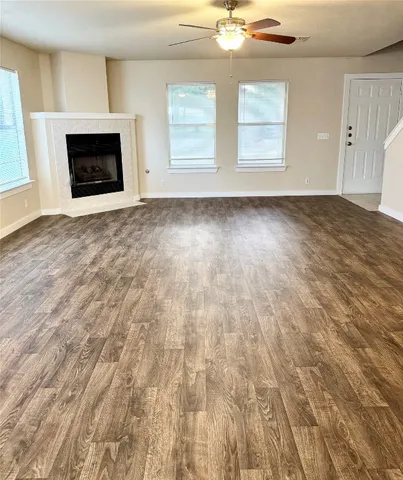 an empty room with windows and fireplace