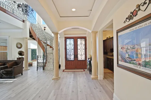 a view of a hallway with wooden floor and furniture