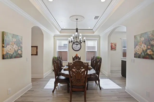 a view of a dining room with furniture wooden floor and a chandelier