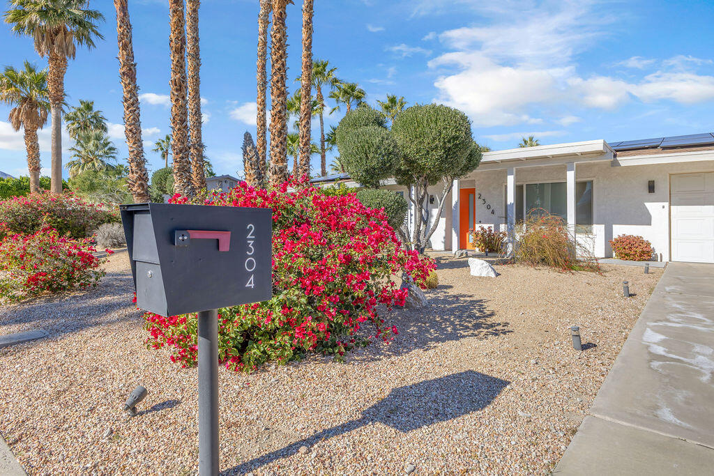 2304 East Bellamy Road Palm Springs, CA 92262 - Photo 26 of 32 a front view of a house with a yard and potted plants