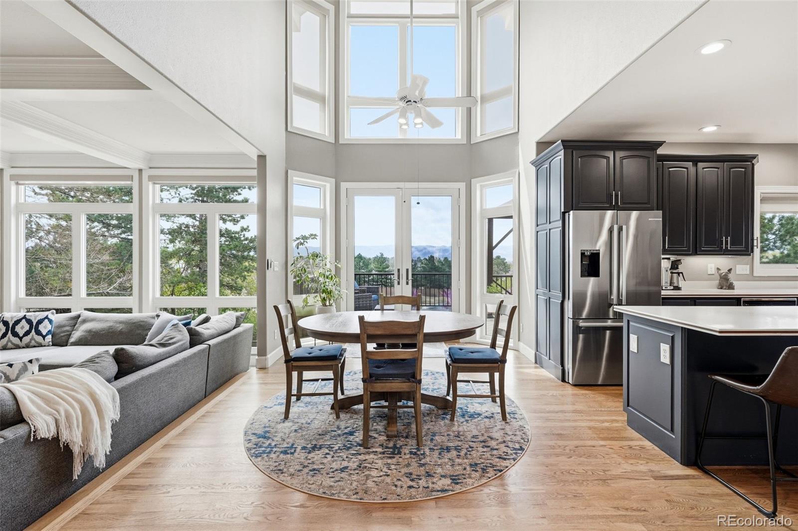 77 Falcon Hills Drive Highlands Ranch, CO 80126 - Photo 14 of 43 a dining room with furniture a chandelier and kitchen view