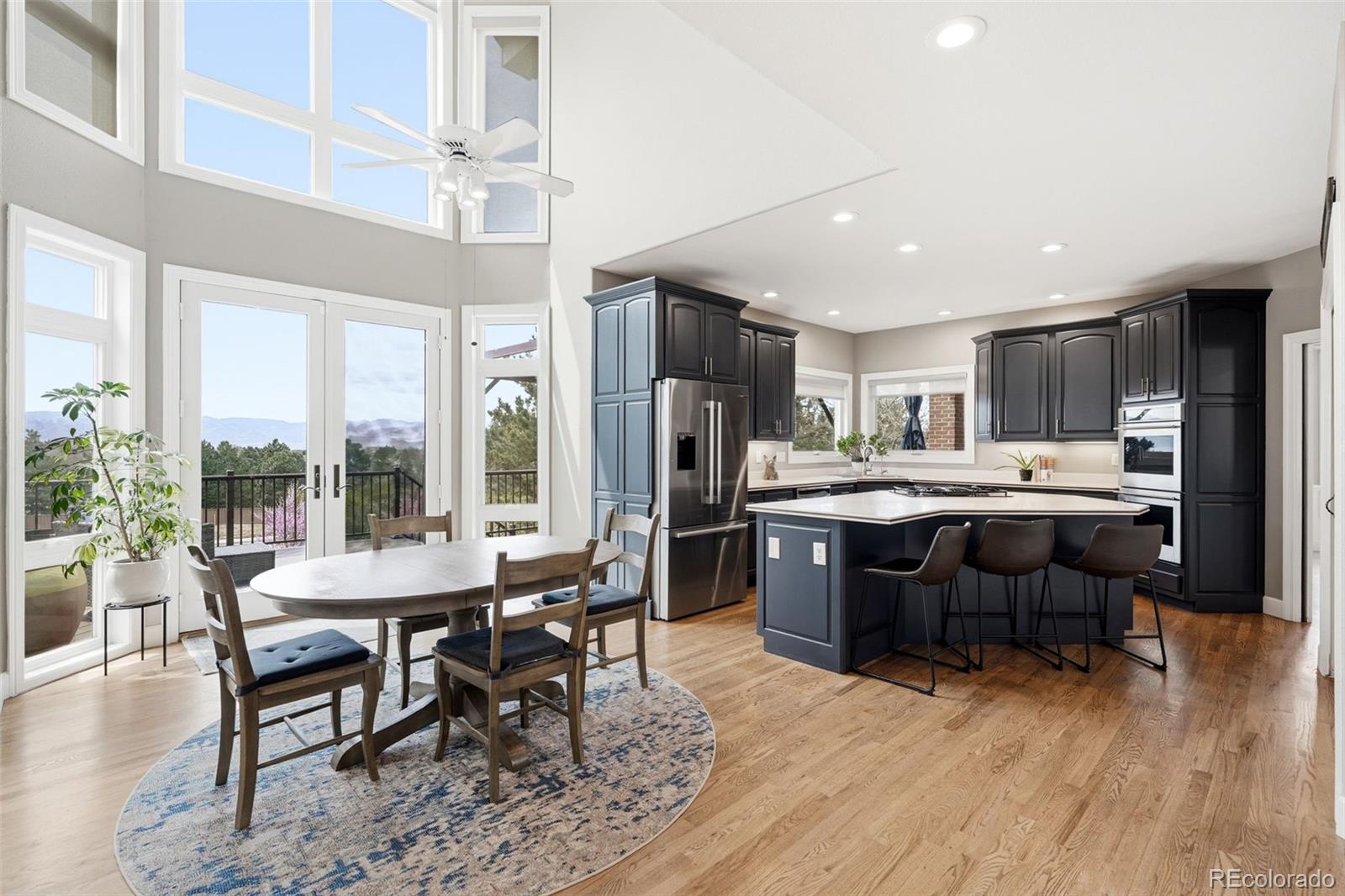 77 Falcon Hills Drive Highlands Ranch, CO 80126 - Photo 15 of 43 a dining hall with stainless steel appliances kitchen island granite countertop a dining table chairs and granite counter tops