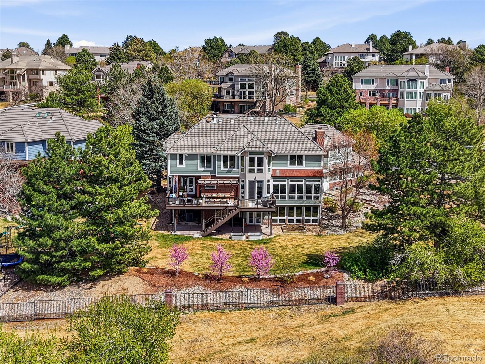 77 Falcon Hills Drive Highlands Ranch, CO 80126 - Photo 2 of 43 an aerial view of a house with swimming pool and a yard