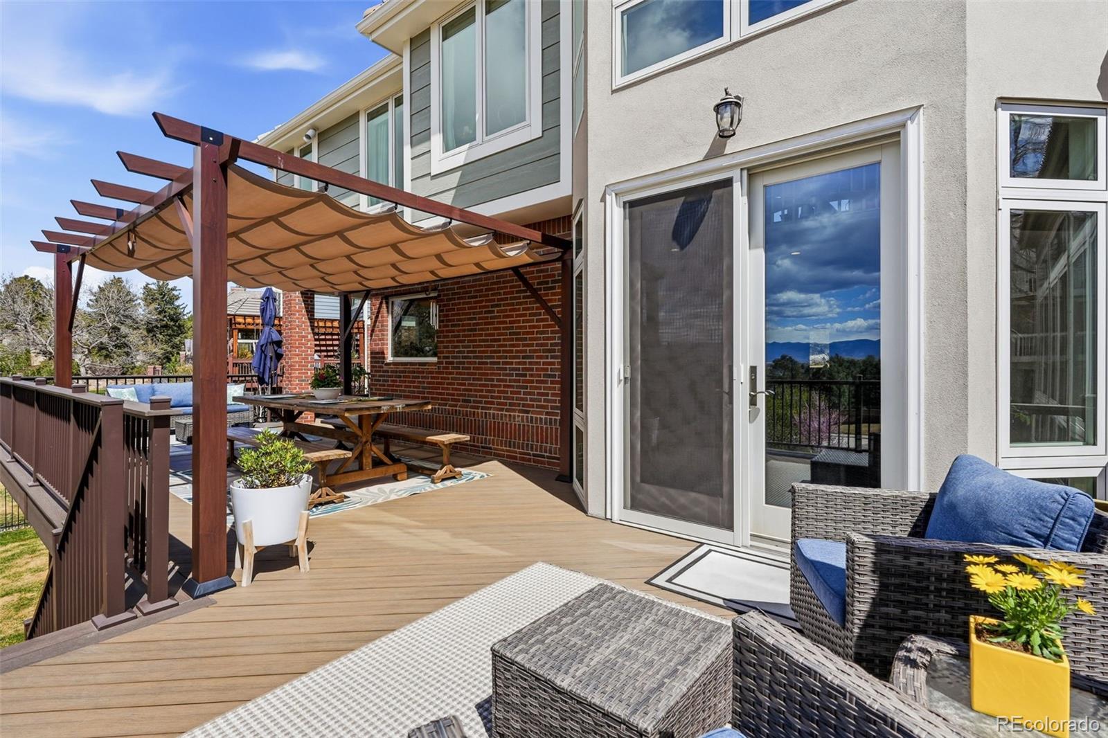 77 Falcon Hills Drive Highlands Ranch, CO 80126 - Photo 35 of 43 a view of a patio with table and chairs with wooden floor and floor to ceiling window