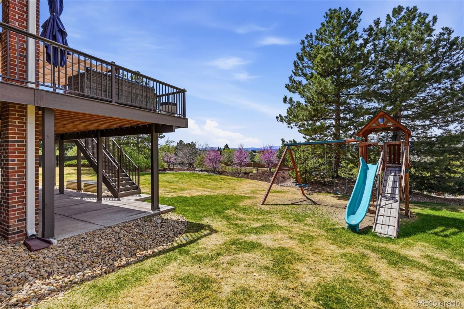 77 Falcon Hills Drive Highlands Ranch, CO 80126 - Photo 36 of 43 a view of a backyard with a slide