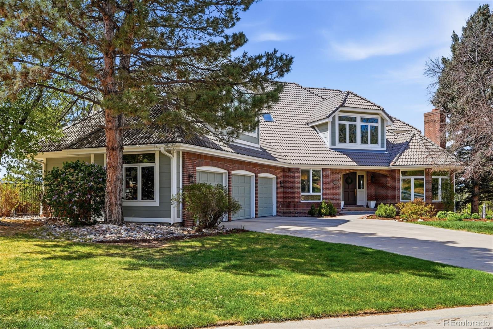 77 Falcon Hills Drive Highlands Ranch, CO 80126 - Photo 6 of 43 a front view of a house with a yard table and chairs