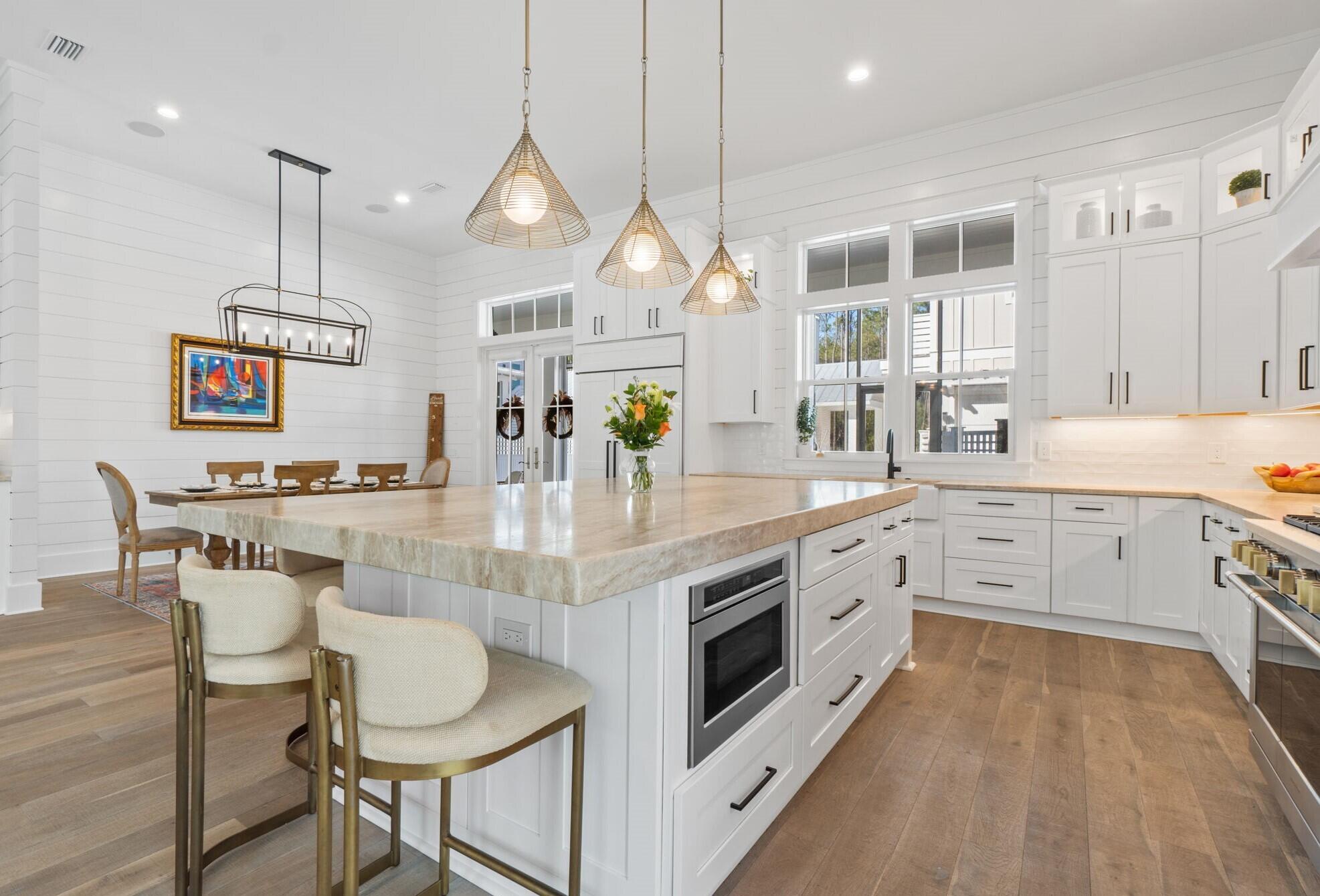 92 Rosecourt Street Inlet Beach, FL 32461 - Photo 12 of 65 a large white kitchen with a lot of counter space and wooden floor
