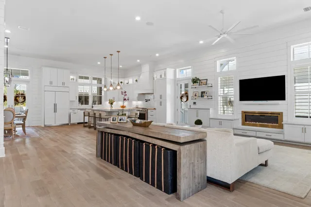 a kitchen with stainless steel appliances kitchen island granite countertop a sink and a stove top oven with wooden floor