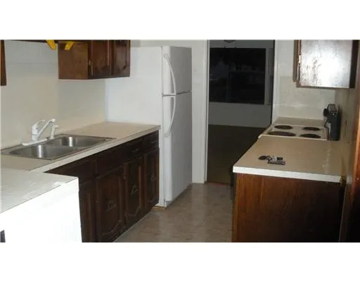 a kitchen with a stove a refrigerator and a sink