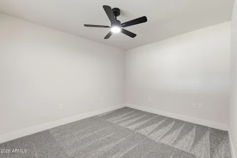 an empty room with a ceiling fan and window