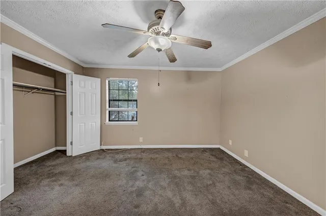 an empty room with windows and fan