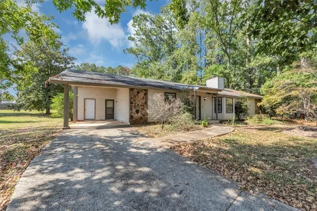 a front view of a house with a yard and trees