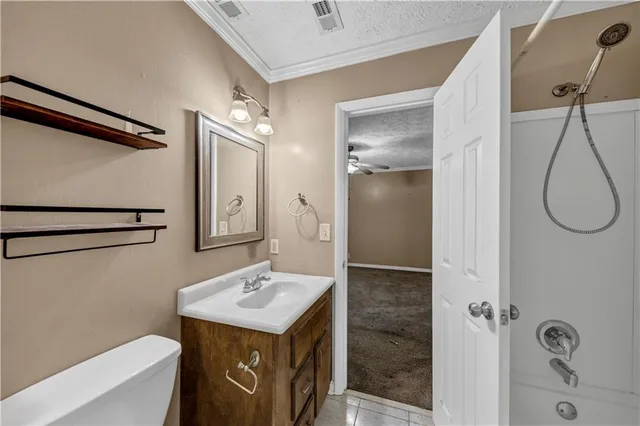 a bathroom with a granite countertop sink a toilet and shower