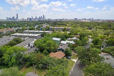 an aerial view of residential house with outdoor space and trees all around