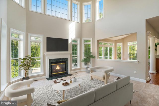 a living room with furniture a fireplace and a large window