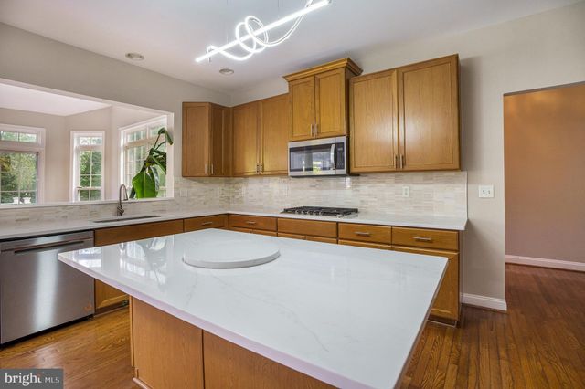 a kitchen with granite countertop a sink a counter top space and cabinets