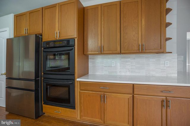 a kitchen with stainless steel appliances granite countertop a stove a microwave a sink and cabinets