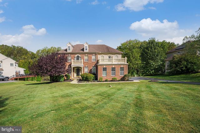 a view of a big house with a big yard and large trees