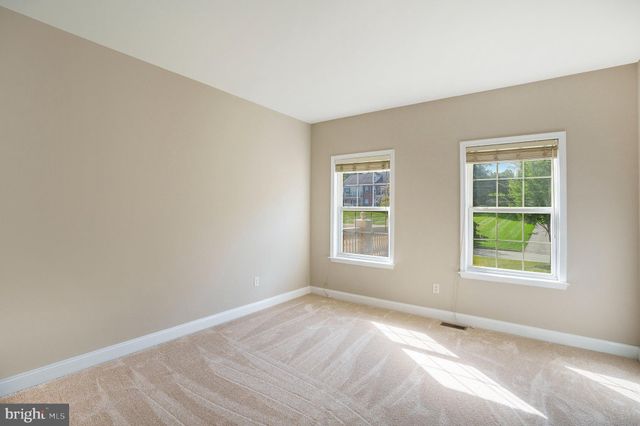 an empty room with windows and ceiling fan