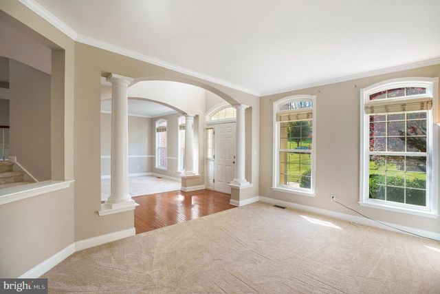 a view of a big room with windows and entryway of the house