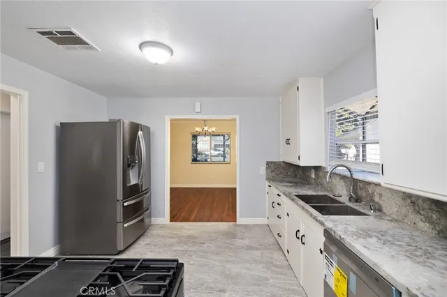 a kitchen with stainless steel appliances granite countertop a sink stove and refrigerator