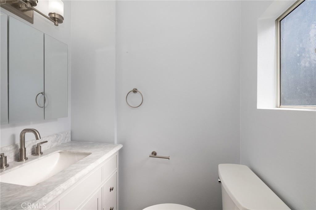 3920 Elma Road Pasadena, CA 91107 - Photo 22 of 29 a bathroom with a granite countertop sink a toilet and mirror