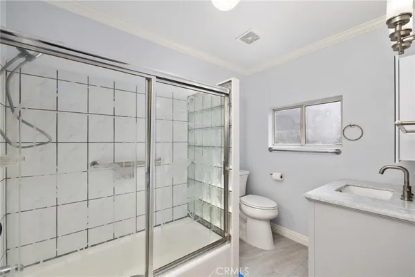 a bathroom with a granite countertop sink a toilet and shower