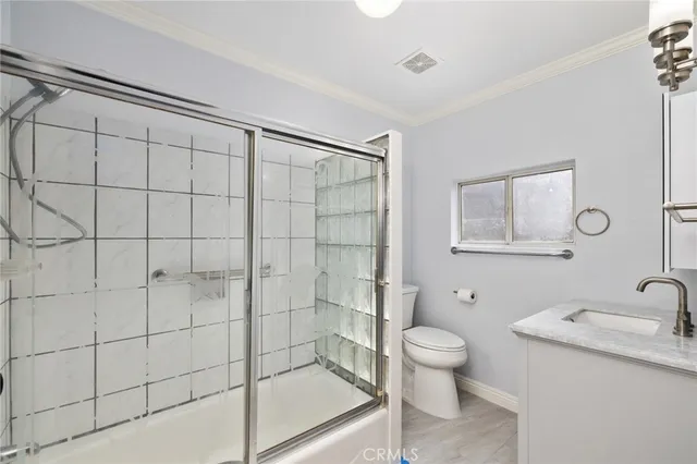 a bathroom with a granite countertop sink a toilet and shower