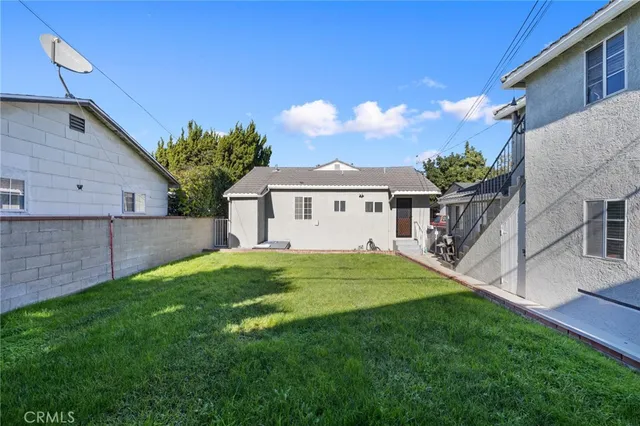 a view of a yard in front of a house with a large tree