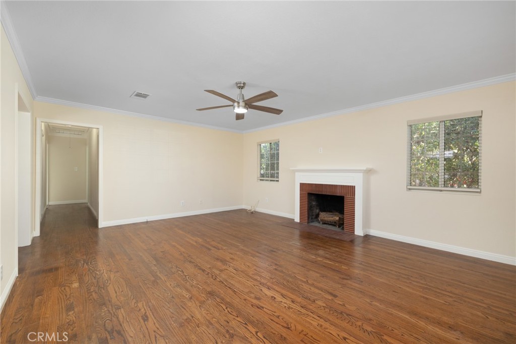 3920 Elma Road Pasadena, CA 91107 - Photo 7 of 29 a view of a livingroom with a fireplace a ceiling fan and wooden floor