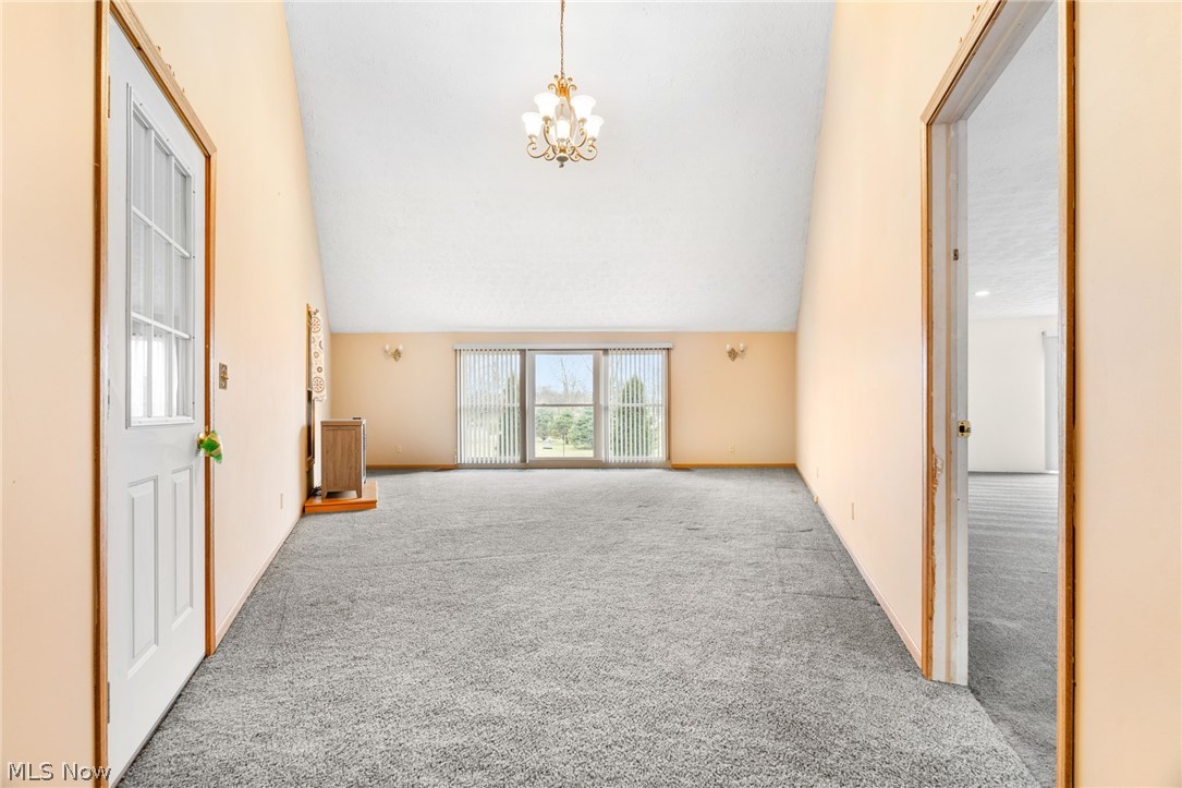 1640 Old Delaware Road Mount Vernon, OH 43050 - Photo 24 of 49 Unfurnished living room with light colored carpet, suspended lighting, and vaulted ceiling