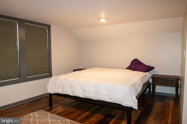 a spacious bedroom with a bed and a dresser