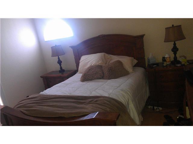 8242 Severn Drive, Unit A Boca Raton, FL 33433 - Photo 11 of 11 a black and white bed in a bedroom next to a lamp
