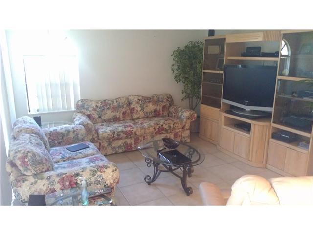 8242 Severn Drive, Unit A Boca Raton, FL 33433 - Photo 2 of 11 a living room with furniture and a flat screen tv